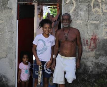 Karen, uma criança do projeto, junto a seu avô e seu irmão, em casa.