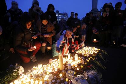 Un grupo de gente coloca velas en Trafalgar Square de Londres.