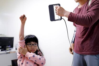 Engineer Chang Hsien-Liang, 46, measures Angel Peng's hand, who injured her hand in a scalding accident when she was nine months old, in Taoyuan, Taiwan, March 17, 2017.         SEARCH "PROSTHETIC 3D" FOR THIS STORY. SEARCH "WIDER IMAGE" FOR ALL STORIES.