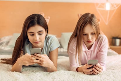 Dos chicas utilizan sus tel&eacute;fonos m&oacute;viles. 