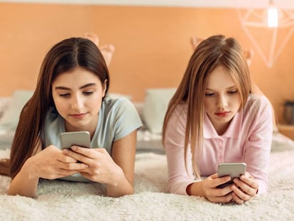 Dos chicas utilizan sus tel&eacute;fonos m&oacute;viles. 