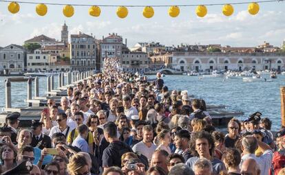 Turistas cruzan el puente hacia la iglesia del Redentor en Venecia (Italia).