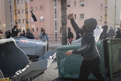 Una persona lanza botellas de cristal para impedir el paso de los furgones policiales, este viernes en Cádiz.