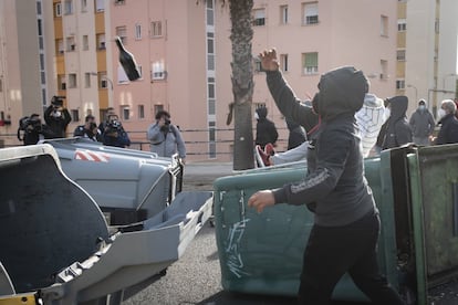 Una persona lanza botellas de cristal para impedir el paso de los furgones policiales, este viernes en Cádiz.