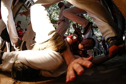 Un mozo tras caer al suelo durante del séptimo encierro de los sanfermines.