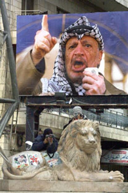 Varios palestinos disparan contra israelíes bajo un cartel de Arafat. En este mismo lugar fue linchado el martes un supuesto colaboracionista.
