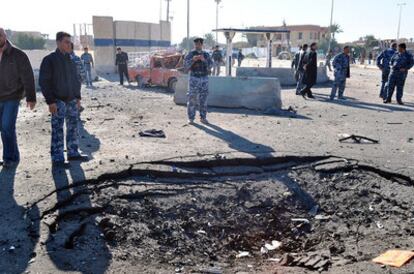 Un policía iraquí contempla el cráter que ha dejado la explosión de un coche bomba en Ramadi.