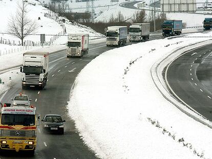 Varios camiones que quedaron atrapados por la nieve circulan por la A-67, a la altura del puerto del Pozazal, tras ser abierta.