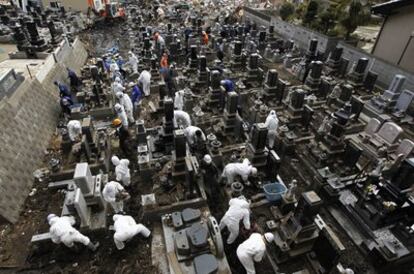 Un grupo de voluntarios ayudan a limpiar un cementerio en el templo de Jionin, en la provincia de Miyagi (noreste de Japón), una de las zonas más afectadas por el terremoto.