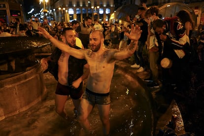 Varias personas en una de las fuentes de la Puerta del Sol, en la madrugada de este domingo.