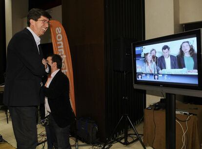 El candidato de Ciudadanos a la Presidencia de la Junta de Andalucia, Juan Mar&iacute;n, a la izquierda, sigue por televisi&oacute;n la intervenci&oacute;n del candidato del PP, Juan Manuel Moreno, tras conocerse el resultado final en las elecciones andaluzas.