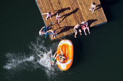 Niños juegan con un bote hinchable en el Lago Heiseder cerca de Hildesheim (Alemania).