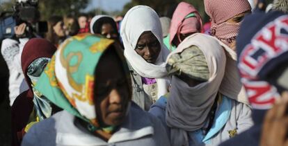 Un grupo de mujeres hace cola para salir del campo de refugiados de Calais (Francia).