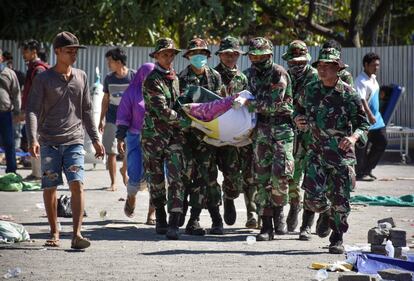 Soldados trasladan el cuerpo de una víctima del terremoto hacia una ambulancia, en Tanjung, el 6 de agosto de 2018. 