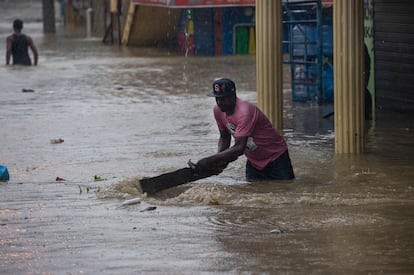 A resident today removes debris in a street flooded due to the passage of tropical storm Franklin, in Santo Domingo, on Aug. 23, 2023.