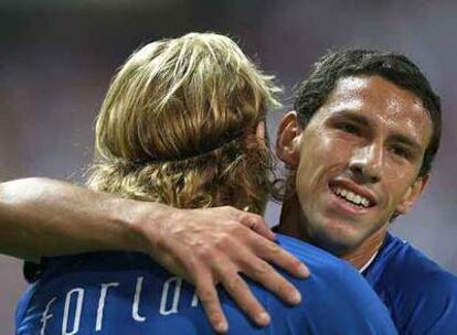 Maxi abraza a Forlán tras el gol del delantero uruguayo.