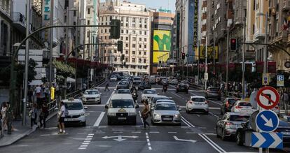irculación de vehículos y peatones en la Gran Vía madrileña.