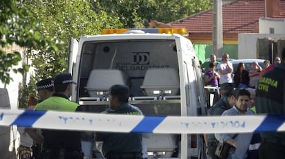 Los agentes, junto al coche con los féretros de los cuatro fallecidos en el incendio de una vivienda en Jaén este sábado.
