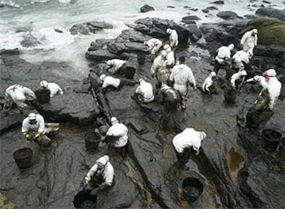 Decenas de voluntarios ayudaron ayer a limpiar de fuel la playa de Coído, en Muxía (A Coruña).