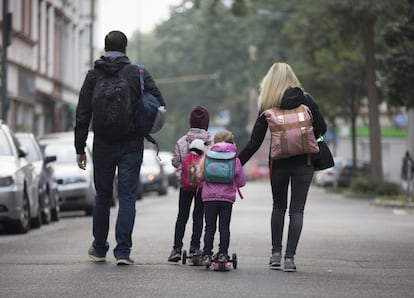 A couple with children  has left their apartment during an evacuation of more than 60 000 people in Frankfurt, Germany, Sunday, Sept. 3, 2017. The evacuation became necessary due to a WW II bomb that will be diffused later in the day.  (Frank Rumpenhorst/dpa via AP)