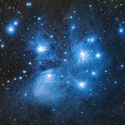 Las Pléyades, M45 o Las siete hermanas es un cúmulo abierto de estrellas en la constelación de Tauro. A simple vista, y en condiciones normales, se pueden distinguir seis estrellas; con un buen cielo es posible observar nueve, y en unas condiciones óptimas hasta 12. Este cúmulo, compuesto por unas 500 estrellas, está situado a unos 450 años luz de la Tierra y tiene un diámetro de unos 12 años luz. Una parte importante de sus estrellas la constituyen enanas marrones y estrellas jóvenes de gran masa. Las estrellas que forman las Pléyades se encuentran envueltas en una nebulosa de reflexión visible a causa del polvo que refleja la luz azul de las estrellas calientes y jóvenes. Se creía que este gas representaba los restos de la formación estelar del cúmulo pero, con una edad de unos 100 millones de años, prácticamente todo el polvo originario debía haber sido dispersado por la radiación estelar. Por ese motivo, se considera que el cúmulo está atravesando una región interestelar especialmente abundante en polvo. La imagen se obtuvo con el telescopio IAC80, en el Observatorio del Teide. Comentario: Pablo Rodríguez Gil y Álex Oscoz Abad.