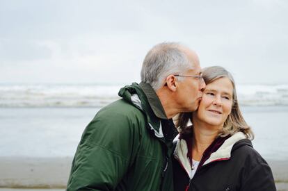 Una pareja pasea por la playa.
