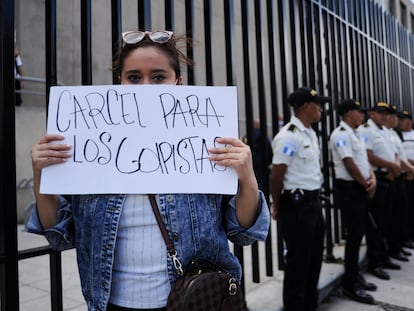 Una mujer muestra un cartel que pide cárcel para los golpistas a las puertas del ministerio público, este jueves en Ciudad de Guatemala.