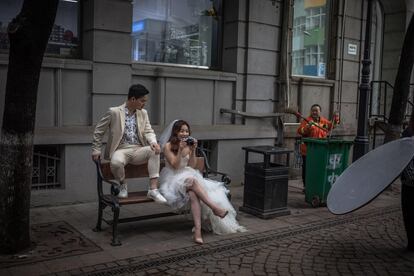 Una pareja posa en la calle para una de sus fotografías preboda, el 29 de abril de 2019, en Wuhan (China).