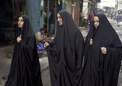 Mujeres iraquíes vestidas con velo negro pasean por un barrio de Bagdad.