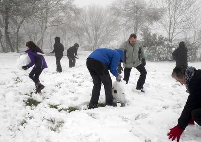 Unos turistas se divierten con la nieve en O Cebreiro (Lugo), donde la temperatura ha bajado bruscamente y se ha producido la primera nevada de la temporada.