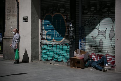 Una persona sin hogar duerme en la plaza del Pedró, en el casco antiguo de Barcelona.