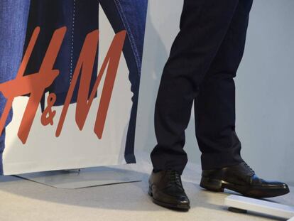 Un hombre al lado de un cartel de H&amp;M en una de sus tiendas