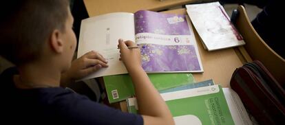 Imagen de archivo de un alumno con un libro de Religi&oacute;n.