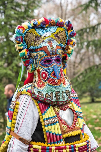 KUKERI (BULGARIA). Habituales del festival Kukerlandia de Yambol, estos disfraces están hechos a mano y llevan lentejuelas, cintas, espejos, pompones y pieles de animales. En ellos no puede faltar un cinturón ancho de cuero del que penden enormes cencerros. Los colores tienen su propia simbología: el rojo representa el fuego solar; el negro, la tierra, y el blanco, la luz y el agua.