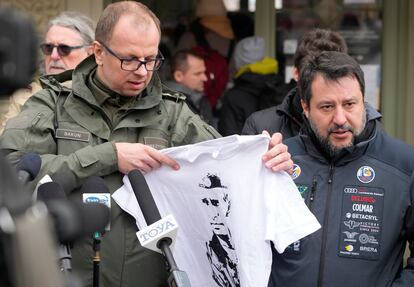 El alcalde de Przemysl, Wojciech Bakun, sostiene una camiseta con la imagen del presidente ruso, Vladímir Putin, mientras el italiano Matteo Salvini habla con los periodistas fuera de la estación de tren en Przemysl (Polonia), este martes.