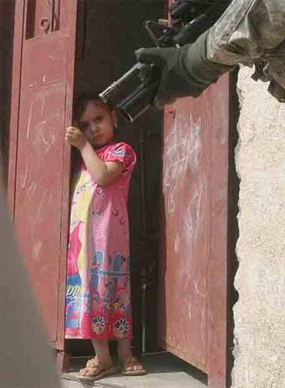 Una niña iraquí mira a un soldado de EE UU ayer en Bagdad.