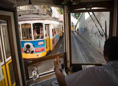 Un viaje a Lisboa (en la fotografía, dos de sus tranvías se cruzan), con vuelos, tres noches de hotel y desayuno, cuesta en Semana Santa 405 euros por persona.