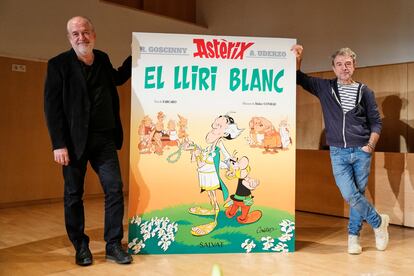 Didier Conrad (i) y el nuevo ilustrador de la serie Fabrice Caro (d) posan con la edición catalana del nuevo álbum de Astérix, 'El lirio blanco'.