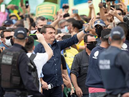 Bolsonaro rodeado de apoiadores em frente ao Palácio do Planalto neste domingo.