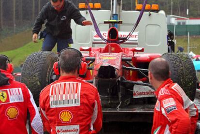 Los mecánicos de Ferrari observan los desperfectos del coche de Fernando Alonso tras chocar contra un muro.