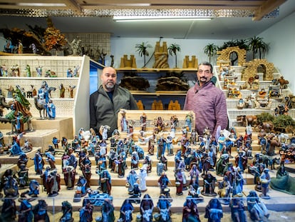 Lino Ferreira y David Ponce (de izquierda a derecha), artesanos de figuras de belenes, en su puesto de la Plaza Mayor, en Madrid.