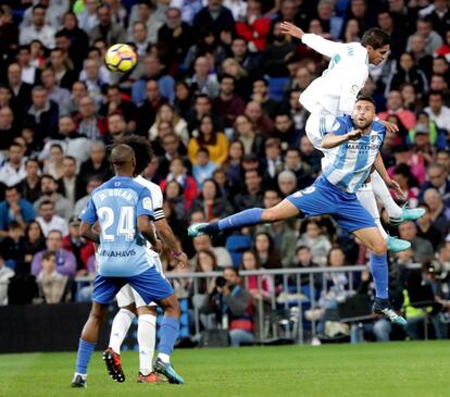 El central francés del Real Madrid Raphael Varane disputa un balón con el delantero del Málaga Borja Bastón.