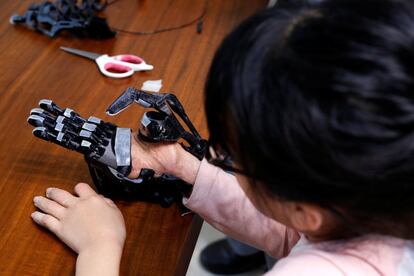Angel Peng, 8, who injured her hand in a scalding accident when she was nine months old, tries on a 3D-printed prosthetic hand designed and built by engineer Chang Hsien-Liang, in Taoyuan, Taiwan, April 6, 2017. REUTERS/Tyrone Siu         SEARCH "PROSTHETIC 3D" FOR THIS STORY. SEARCH "WIDER IMAGE" FOR ALL STORIES.