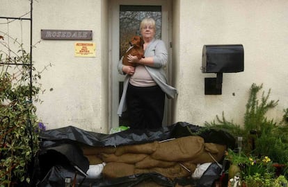 Lesley Haughton de 67 años retratada en su casa junto a su perro. Su mascota sería lo primero que Lesley rescataría de su casa en caso de inundaciones.