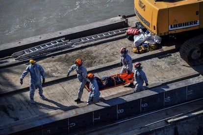Miembros de los servicios de rescate recuperan el cuerpo de una de las víctimas mortales del barco naufragado en el río Danubio a la altura del puente Margarita en Budapest (Hungría) este martes. Algunos cadáveres han sido localizados a 100 kilómetros del lugar del accidente.