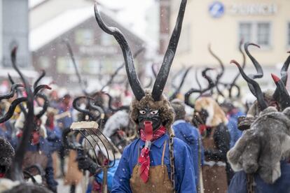 Um grupo de pessoas mascaradas dançando no tradicional desfile de carnaval "Suehudi" em Einsiedeln (Suíça), em 12 de fevereiro de 2018.