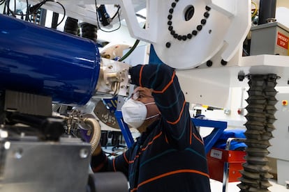 Un trabajador realiza ajustes a las máquina receptora de información satelital.