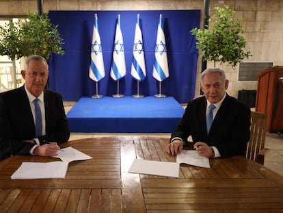 Netanyahu, a la derecha, firma junto al centrista Beny Gantz el acuerdo alcanzado este lunes.