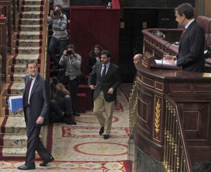 Zapatero espera a que Rajoy se siente en su escaño para iniciar el turno de réplica.