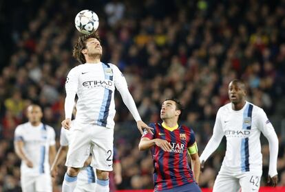 David Silva intenta el remate ante la mirada de Xavi